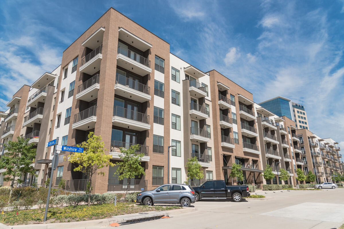 Four-story apartment community on a sunny day